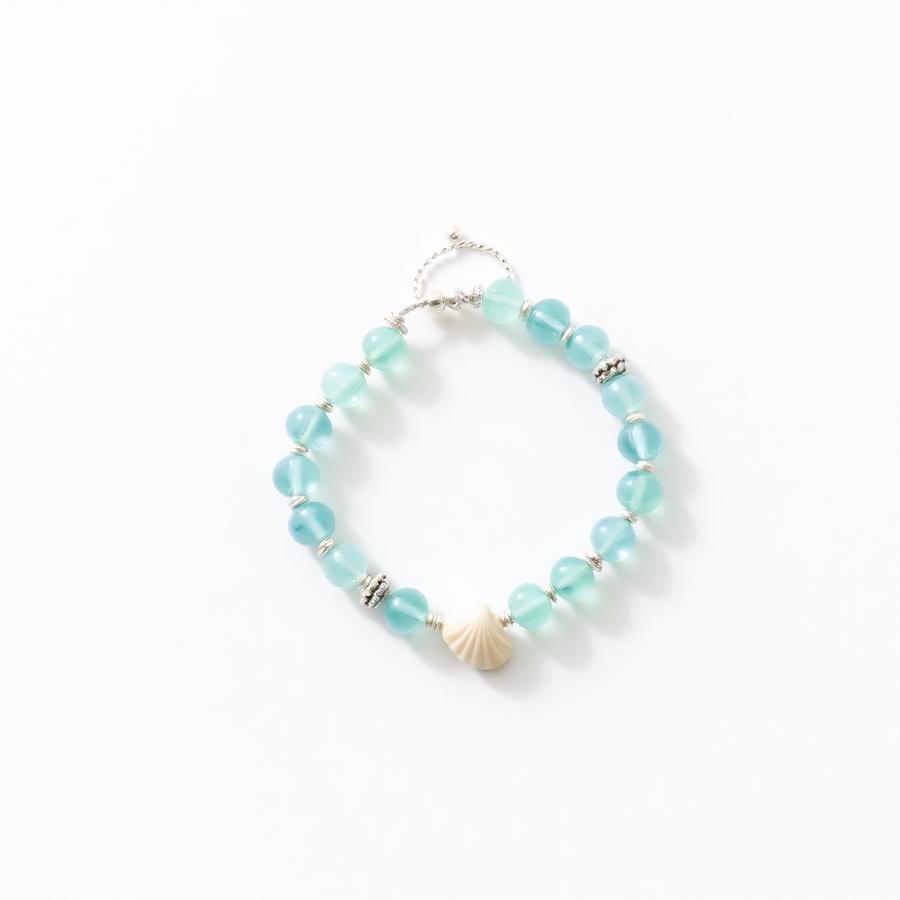 Ocean Breeze handmade beaded bracelet β Soft blues and seafoam greens with a tiny seashell charm.